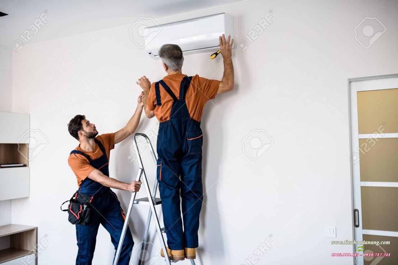 Two Workers In Uniform, Air Conditioning Masters Using Ladder While Installing A New Air Conditioner In The Apartment. Construction, Maintenance And Repair Concept Stock Photo, Picture And Royalty Free Image. Image 152085753.